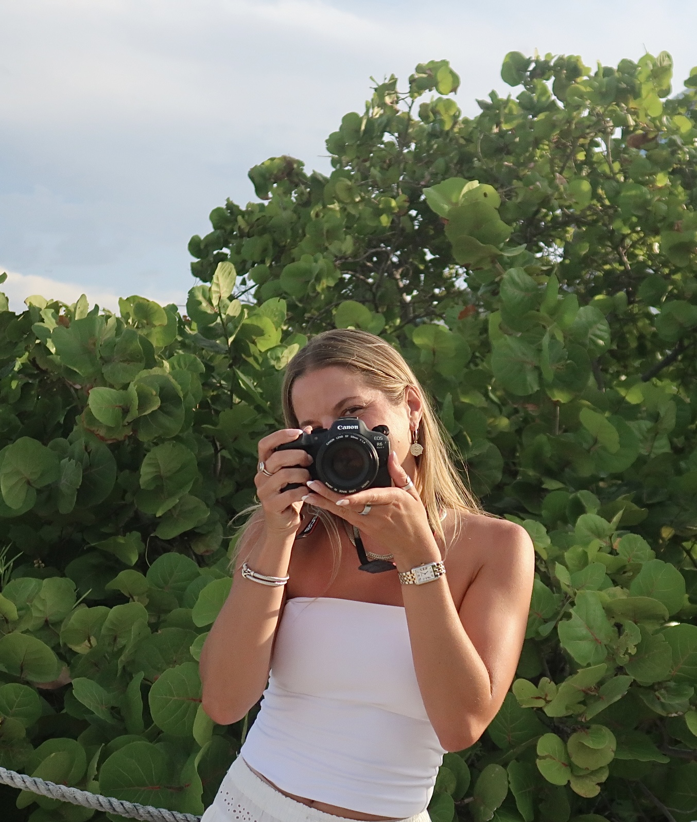 Shannon photographing with a Canon camera among sea grape leaves